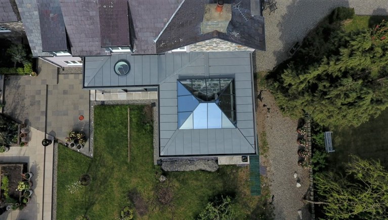 Zinc roof with flat circular roof light and a large 'Atlas' slim line aluminium roof structure